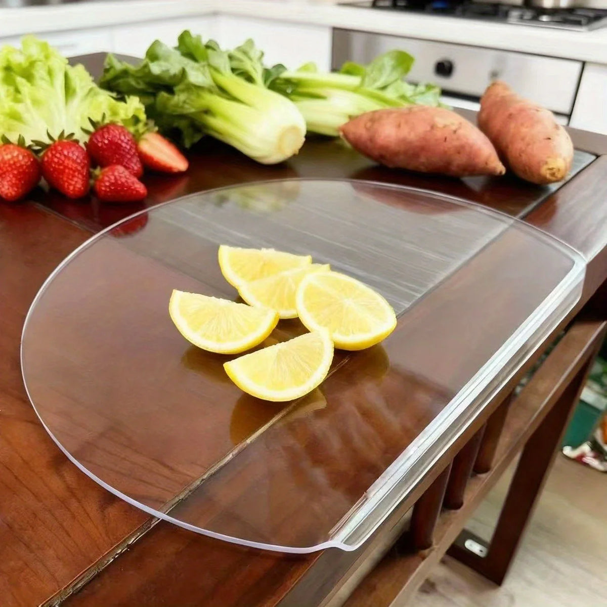 Transparente ovale Tischunterlage auf Holztisch – zwei Äpfel und eine Zitrone von oben